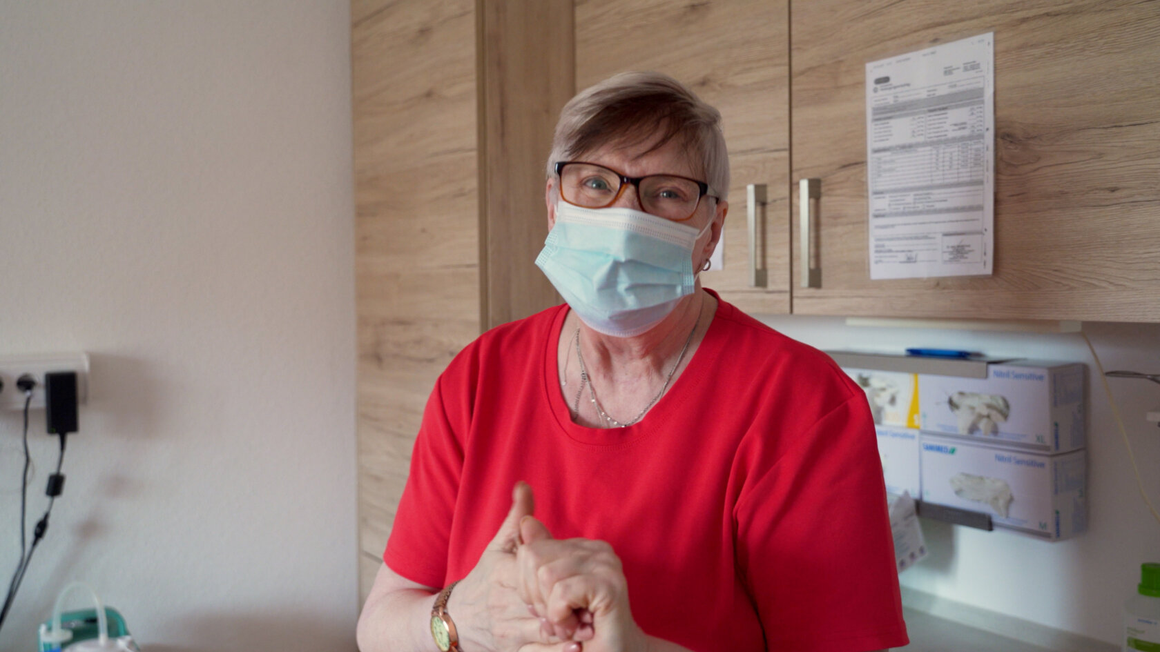 Pflegefachkraft mit medizinischer Maske bei der Arbeit